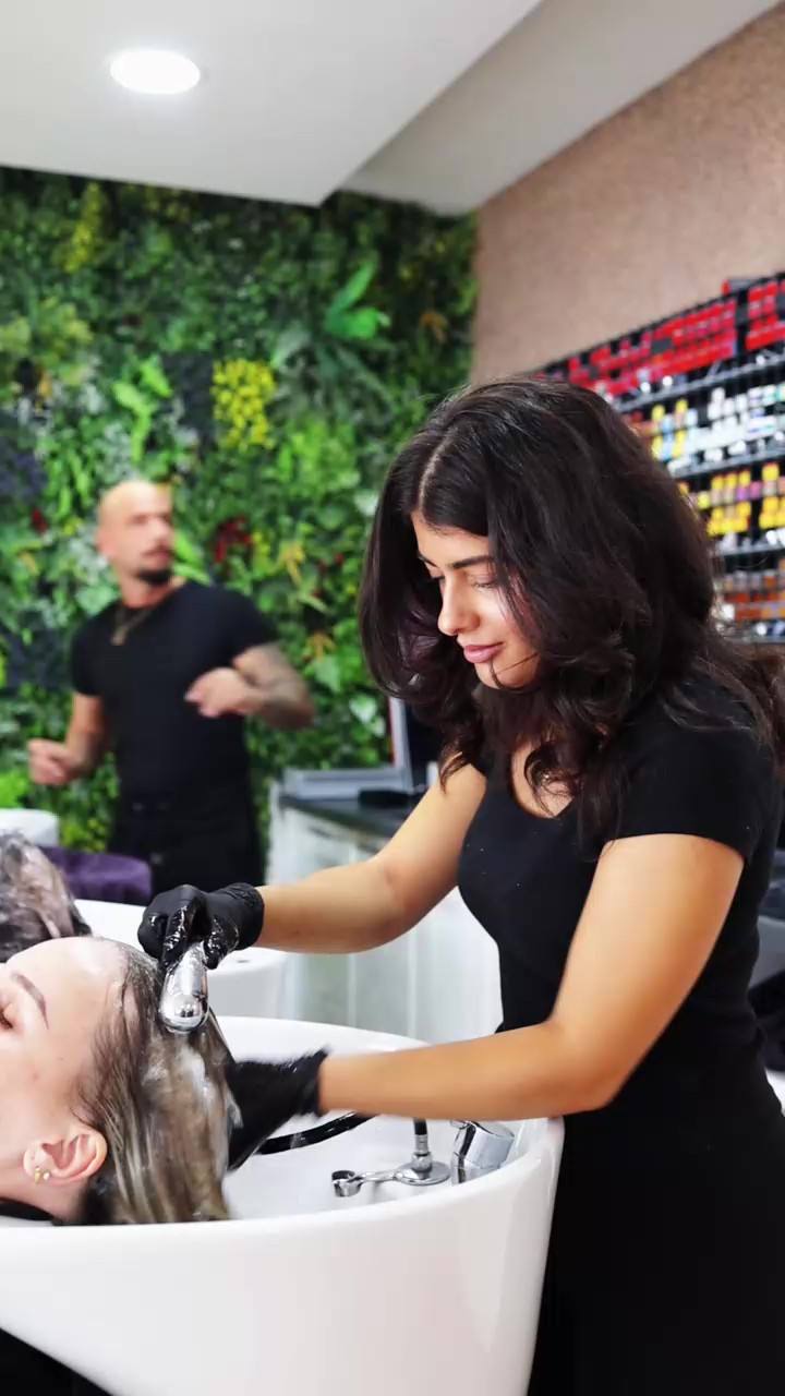 Friseurin trägt im Salon Farbe auf