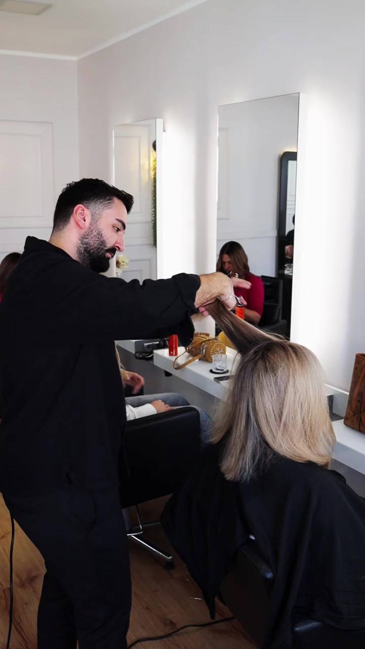 Friseurin föhnt einer Kundin die Haare