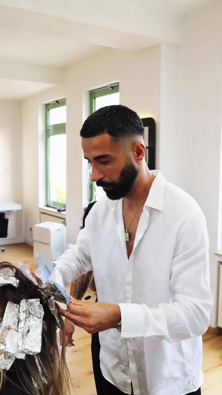 Friseur schneidet einer Kundin die Haare