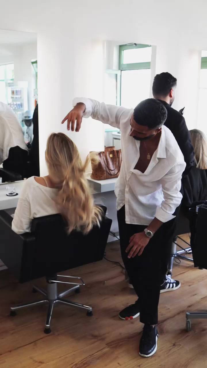 Stylist richtet einer Kundin die Haare
